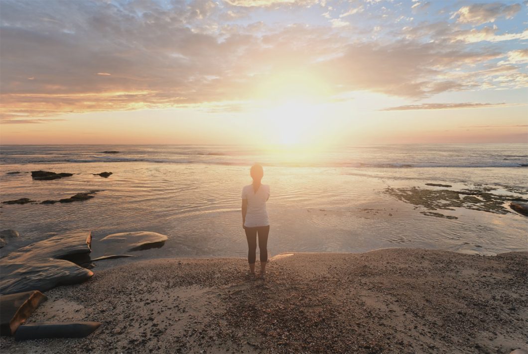 woman on a beach at sunrise